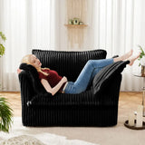 Black corduroy deep seat modern sofa with a reclining woman lounging peacefully