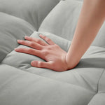 Soft gray quilted mattress topper being pressed on a Grey Velvet Chair Bed Sleeper for Small Spaces