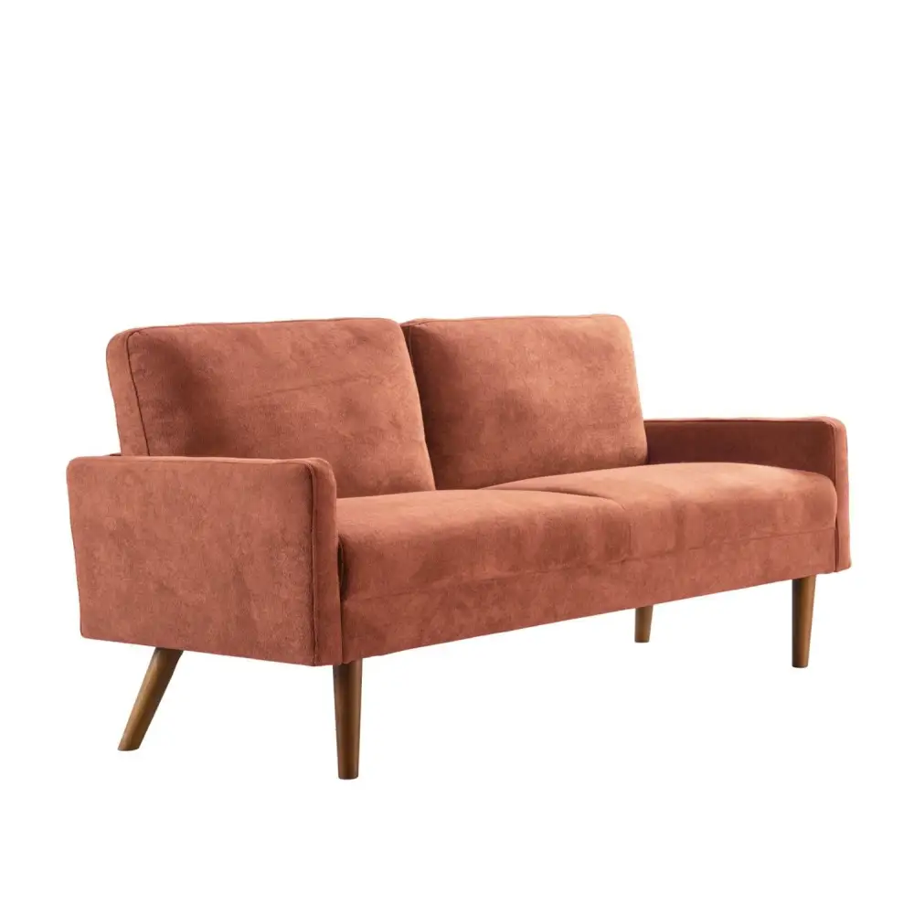 Salmon-colored velvet couch with wooden legs in chic living room setting