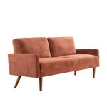 Salmon-colored velvet couch with wooden legs in chic living room setting