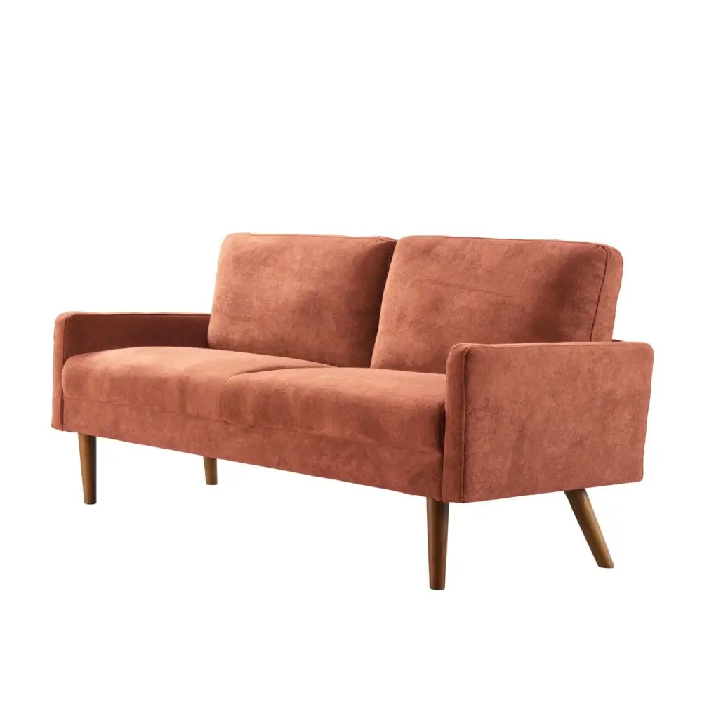 Salmon-colored velvet couch with wooden legs for a chic living room setting