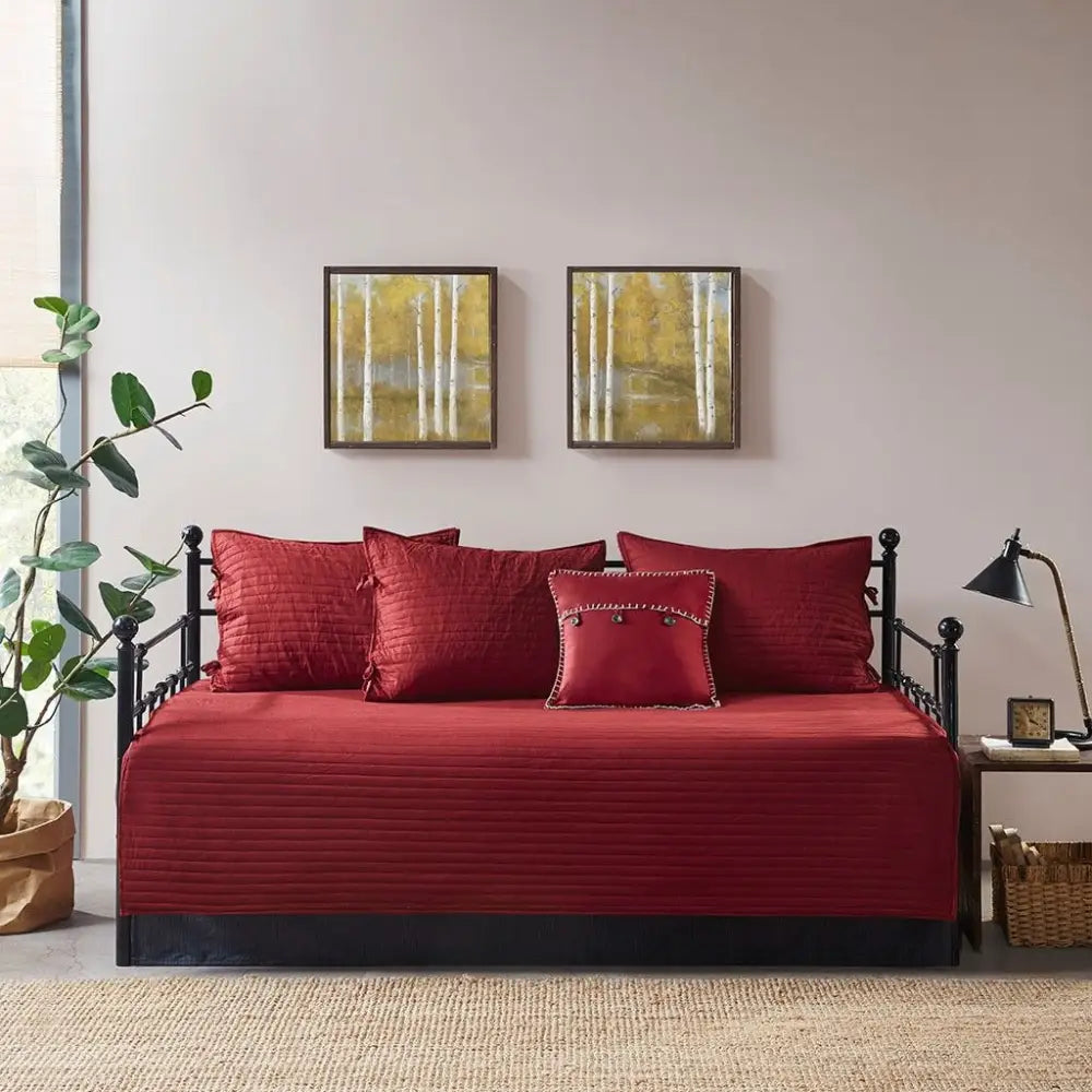 Red plaid reversible daybed cover set with decorative pillows on a stylish daybed