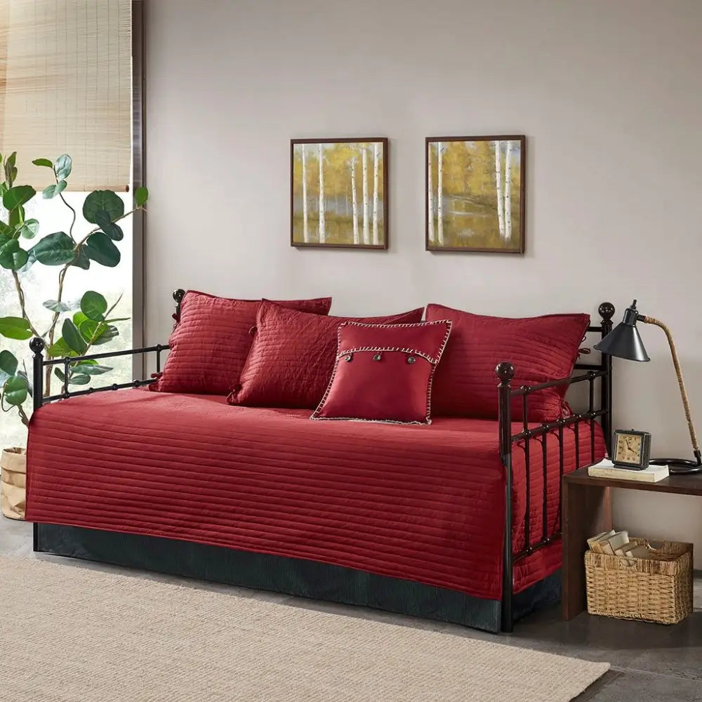 Red plaid reversible daybed cover set with decorative pillows on a stylish daybed
