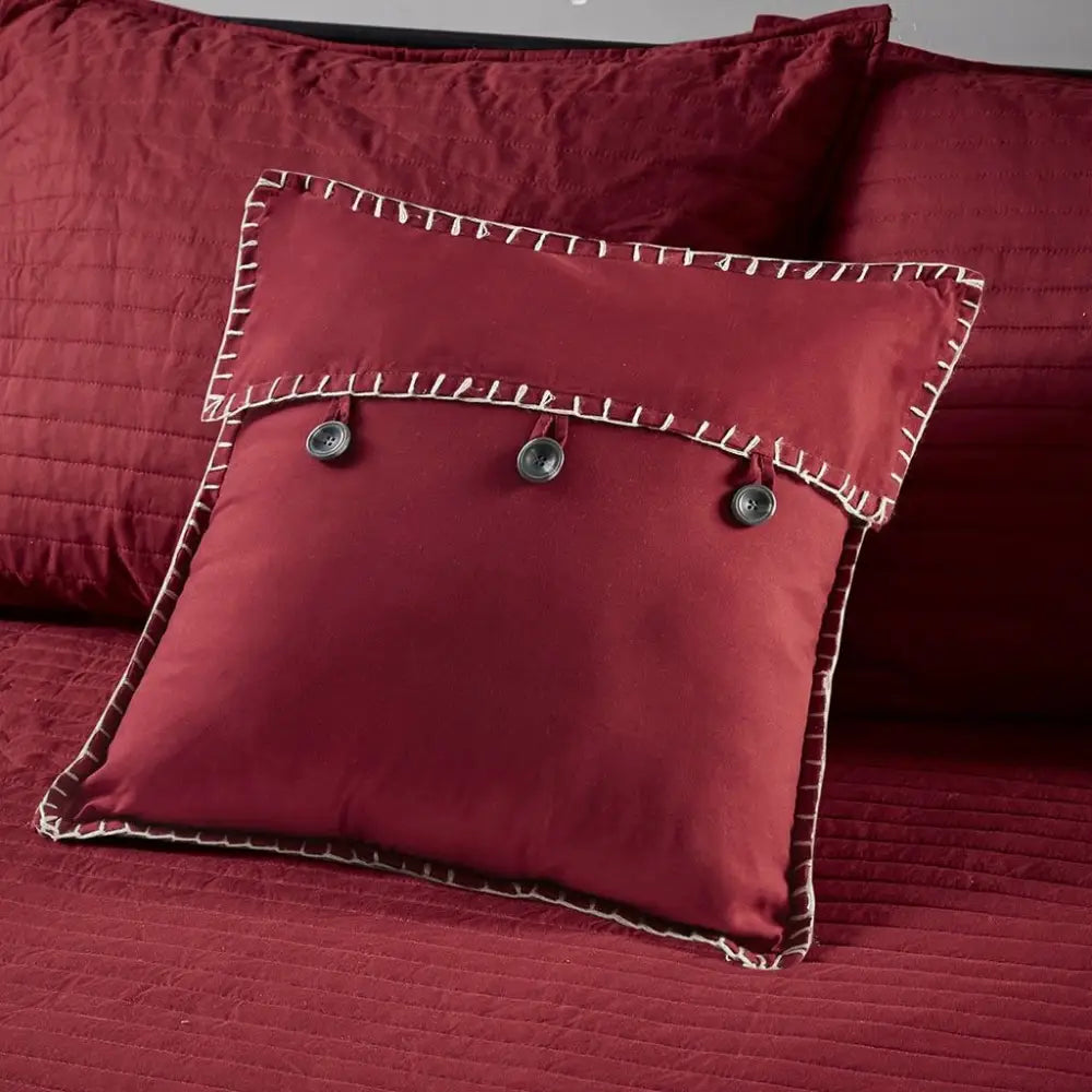 Maroon decorative pillow with button accents on Red Plaid Reversible Daybed Cover Set