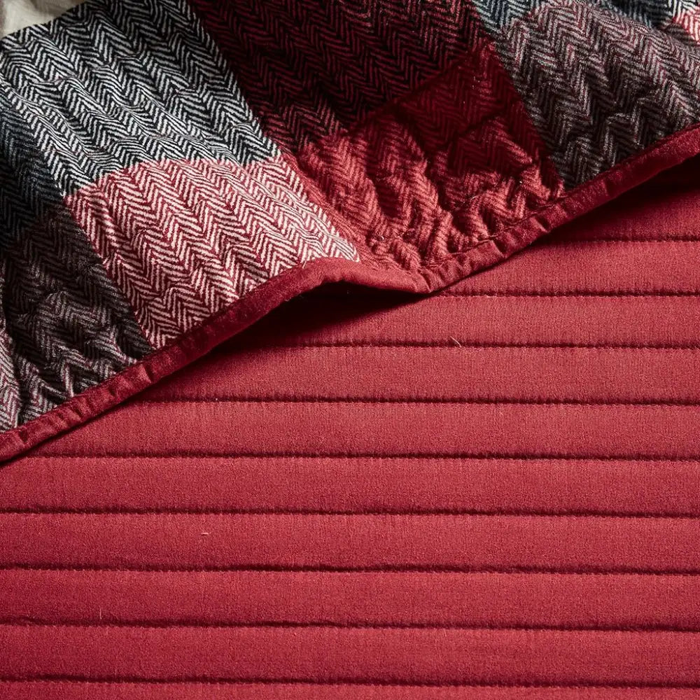 Red and herringbone patterned quilted fabric on a reversible daybed cover set