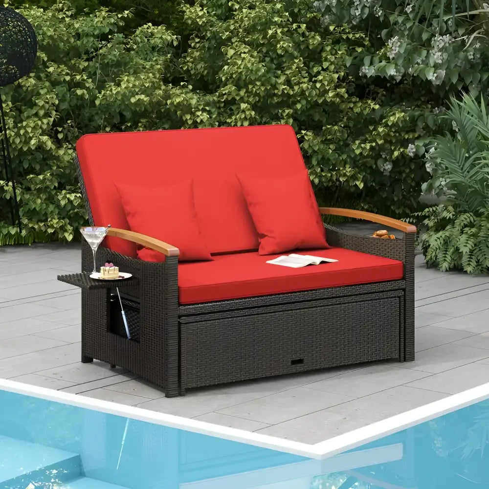 Wicker loveseat with red cushions in a conversation set featuring ottoman cushion and sturdy design